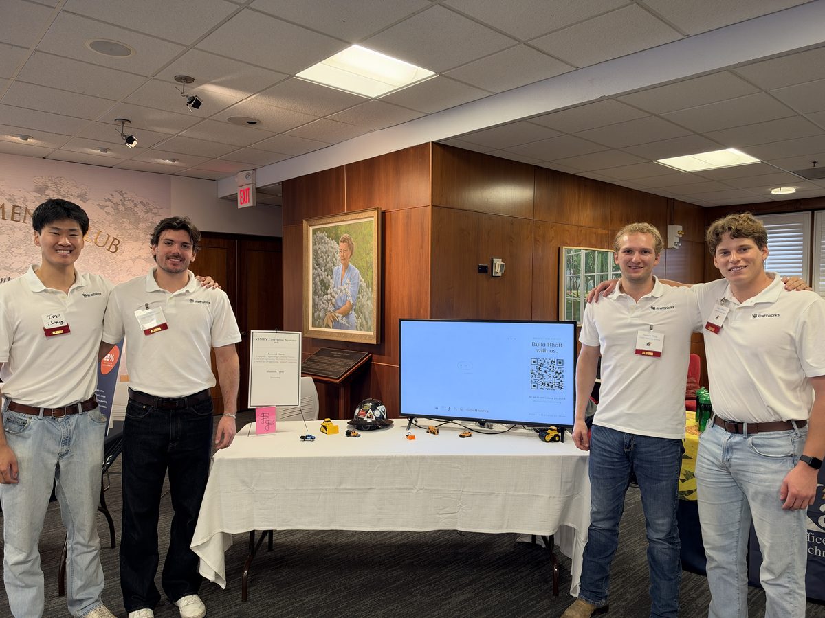 The RhettWorks team in matching white polos at a career fair booth. Left to right: Ivan, Kyle, Aamon and Hale.